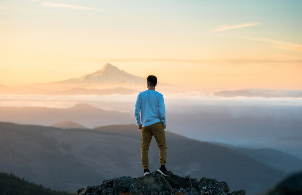 Person overlooking a mountain top which could be interpreted as an aspiring Entrepreneur